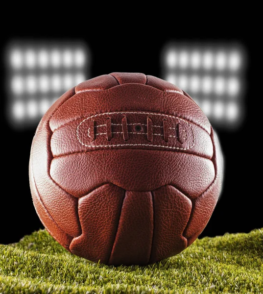 Old football over green grass — Stock Photo, Image