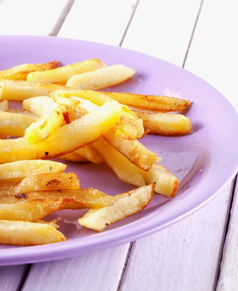 Batatas fritas sobre uma placa roxa — Fotografia de Stock