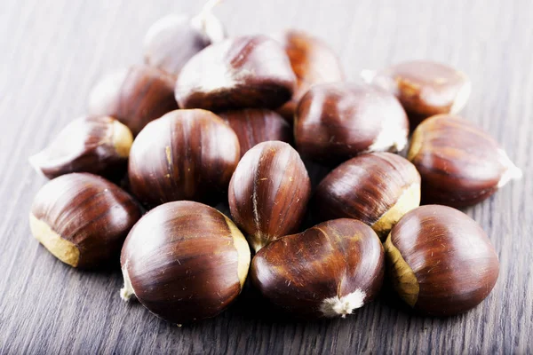 Castanhas sobre mesa de madeira — Fotografia de Stock