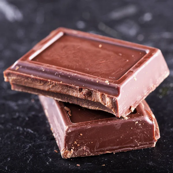 Chocolat en blocs sur fond noir — Photo