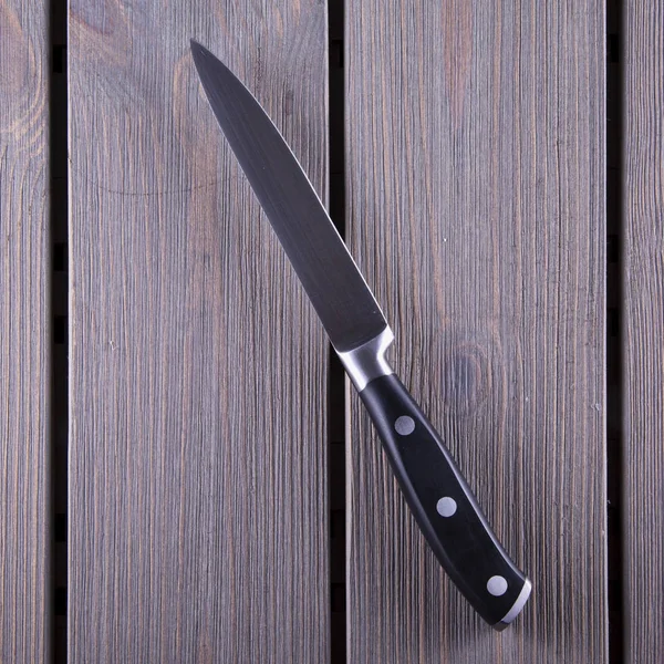 Μαχαίρι κουζίνας πάνω από το ξύλινο τραπέζι — Φωτογραφία Αρχείου