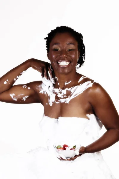 Афроамериканка улыбается, покрытая белым кремом — стоковое фото