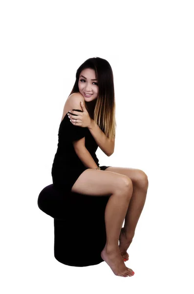 Asiática americana mujer sentado en taburete en negro vestido —  Fotos de Stock