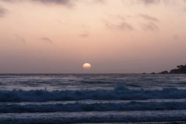 Pôr-do-sol no céu nublado com ondas oceânicas — Fotografia de Stock