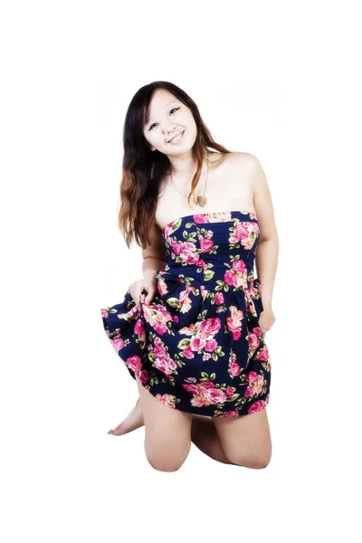 Lächelnde chinesisch-amerikanische Frau kniet im Kleid — Stockfoto