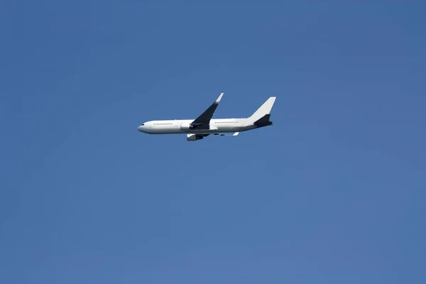 Коммерческий реактивный самолет, летящий в ясном голубом небе — стоковое фото