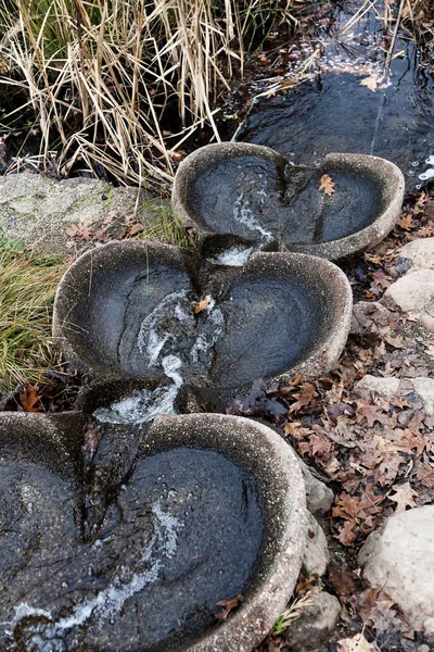 Фонтан с водяным потоком стекает в пруд — стоковое фото
