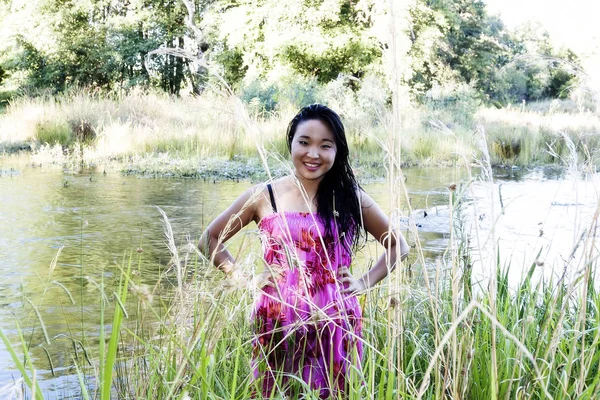 Japonês americano mulher no rio sorrindo no vestido floral — Fotografia de Stock