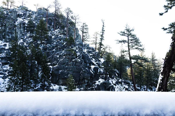 Falaise de rocher avec des arbres éparpillés et de la neige — Photo