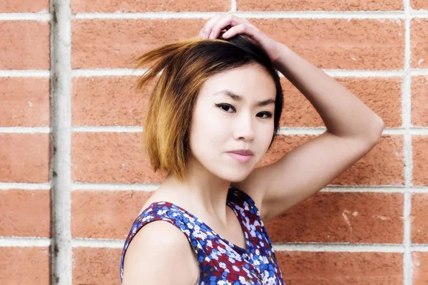 Vonzó ázsiai-amerikai nő portré a téglafal — Stock Fotó