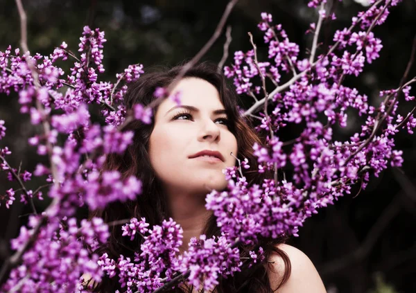 Szabadtéri portré fiatal kaukázusi nő közepén tavaszi virágok — Stock Fotó