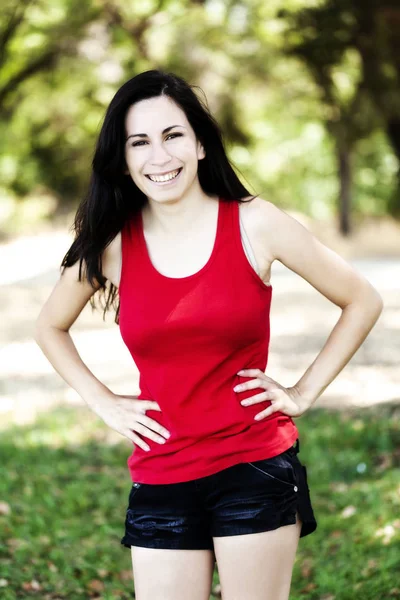 Sorrindo hispânico adolescente mulher ao ar livre vermelho superior e shorts — Fotografia de Stock