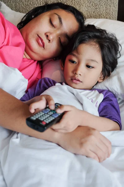 Asiatico bambino su letto godere utilizzando telecomando a guardare tv — Foto Stock