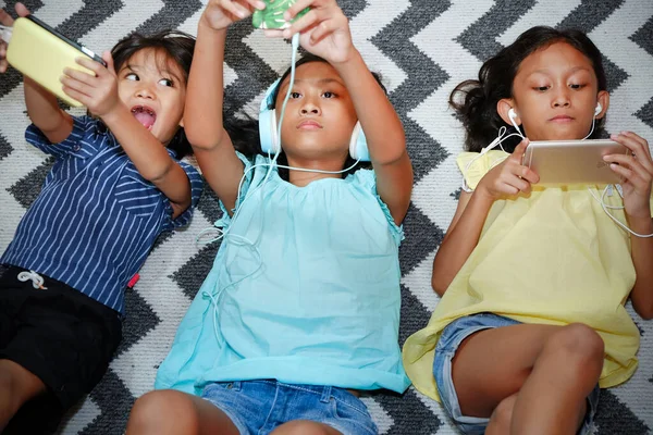 Southeast Asian Ethnic Children Laying Together Carpet Home Playing Smartphone — Stock Photo, Image