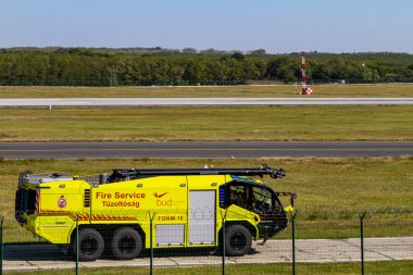 Budapest Hungary Sept. 22, 2019: An emergency rescue/ firetruck carries out a short exercising at the end of the international airport runway. 