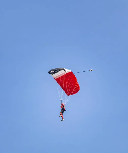 Pára Quedas Descendo Com Paraquedas Vermelho Contra Céu Azul — Fotografia de Stock