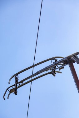 Mavi gökyüzünün arka planında yüksek voltajlı güç hattı