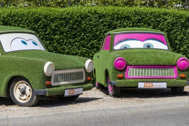 Sopron Macaristan 2 Mayıs 2020: İki Doğu Alman arabası - ünlü TRABANT - tamamen yapay çim ile donatılmış Hwy tarafından sergilenmektedir. Erkek ve Kadın
