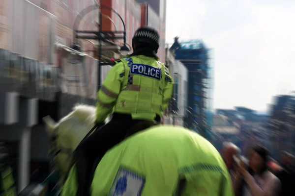 Reino Unido mulher da polícia a cavalo de volta — Fotografia de Stock
