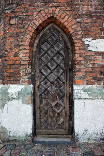Smalle gotische houten deur naar een kerk — Stockfoto