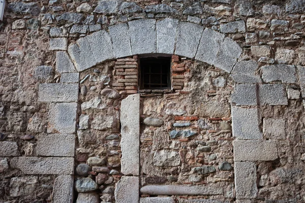 Старая каменная стена со встроенной аркой — стоковое фото