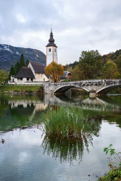 Church tower and stone bridge at Lake Bohinj — Stock Photo, Image