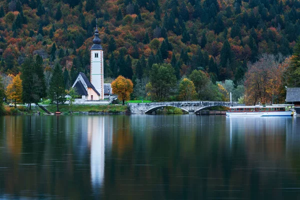 Torre da igreja e ponte de pedra no Lago Bohinj — Fotografia de Stock