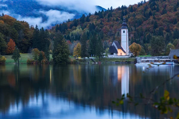 Kościół wieża i kamienia most nad jeziorem Bohinj — Zdjęcie stockowe