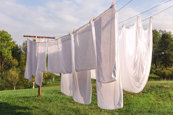 Постільна білизна висить на лінії одягу і сушиться — стокове фото