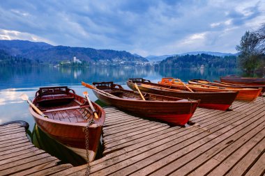 Geleneksel ahşap tekneler Pletna üzerinde Kilise Lake Bled, Slovenya adada backgorund. Europe.