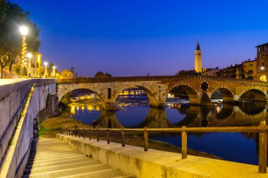 Ponte Pietra Adige Nehri geceleri vardır. Campanile di Santa Anastasia Verona arka planda görünür. 