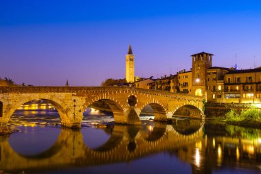 Ponte Pietra Adige Nehri geceleri vardır. Campanile di Santa Anastasia Verona arka planda görünür. 