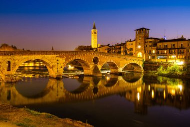 Ponte Pietra Adige Nehri geceleri vardır. Campanile di Santa Anastasia Verona arka planda görünür. 