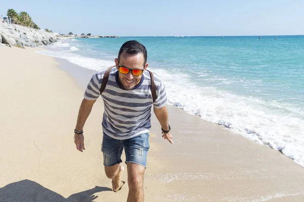 Retrato de um jovem barbudo em pé na praia em um dia ensolarado — Fotografia de Stock