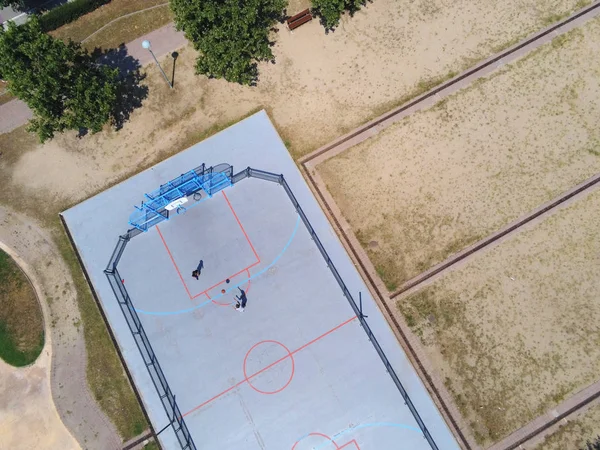 Pandangan udara tentang dua remaja yang tidak dikenal bermain basket di lapangan kota pada hari yang cerah — Stok Foto