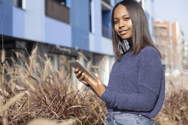 Portrait of African American young beautiful woman standing on the street while using a mobile phone — 스톡 사진