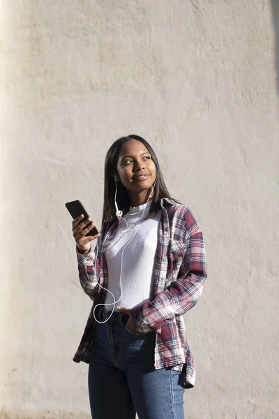 Portrait of African American young beautiful woman standing on the street while using a mobile phone — 스톡 사진
