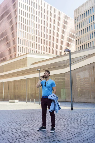 屋外に立っている間に電話と笑顔で話す陽気な現代ビジネスマンの肖像 — ストック写真