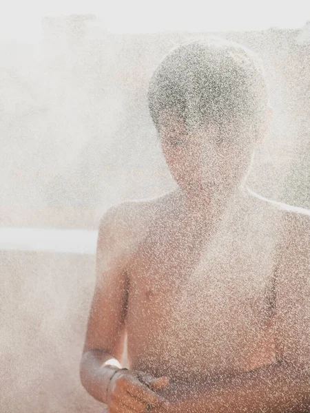청소년은 테라스에서 호스로 샤워를 즐기며 즐거워 — 스톡 사진