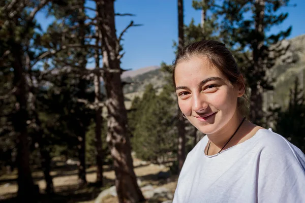 Tişörtlü Genç Kız Arka Planda Ormanla Gülümserken Ayakta Duruyor — Stok fotoğraf