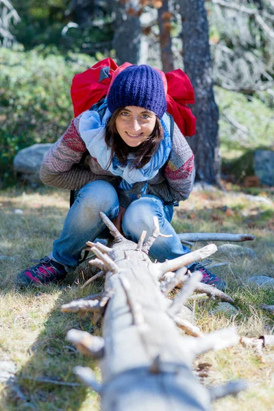 Glimlachende Backpacker Vrouw Met Wollen Kap Zittend Een Boomstam Grond — Stockfoto