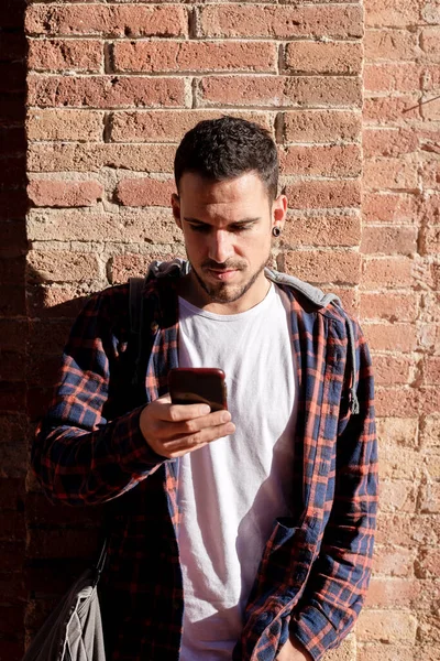 Young Bearded Man Leaning Bricked Wall While Using Smartphone — Stock Photo, Image