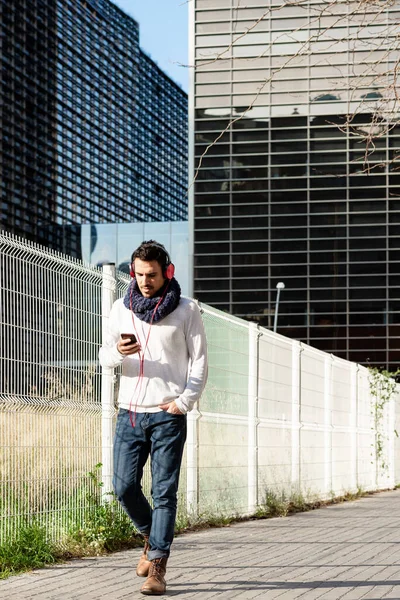 Junger Bärtiger Mann Mit Kopfhörern Und Smartphone Beim Gehen Gegen — Stockfoto