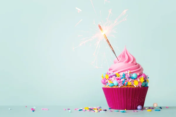 Birthday cupcake with sparkler and sprinkles — Stock Photo, Image