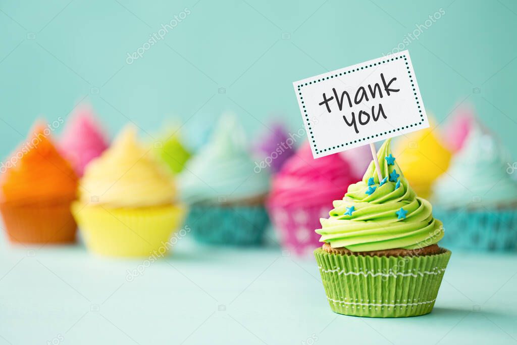 Assortment of colorful cupcakes with thank you sign