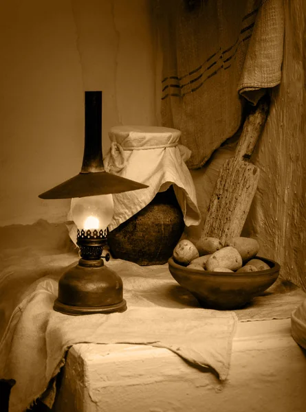 Vida antiga imóvel. Batatas com lâmpada de querosene — Fotografia de Stock