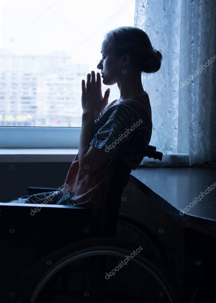 Disabled person in stroller by window