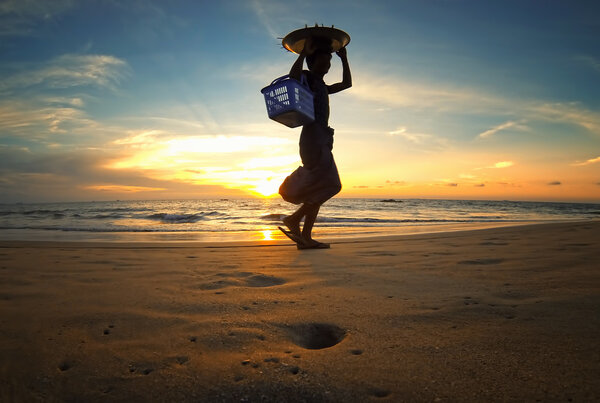 Bay of Bengal at sunset with silhouette of asian food seller