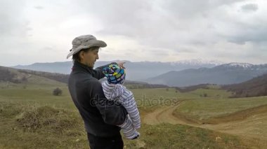 Babası onun oğlunu dağlarda yürüyüş sırasında Ermenistan'da gösterir.