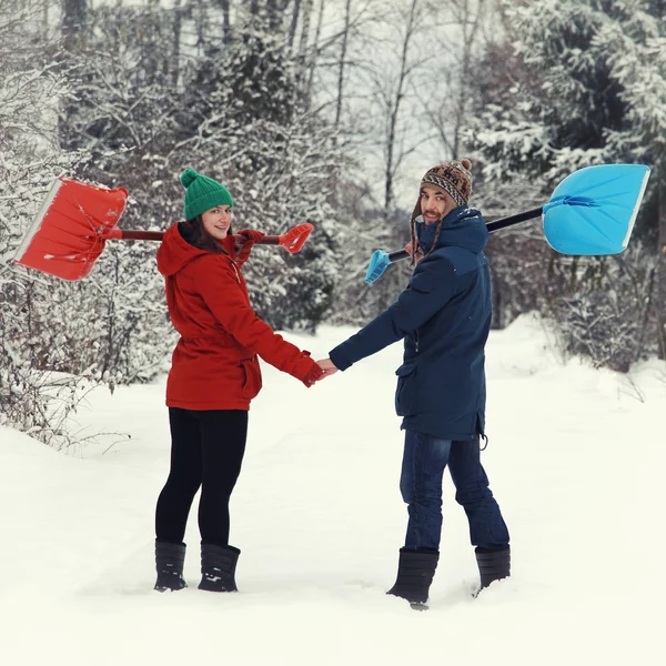 雪のシャベルで幸せなカップル — ストック写真